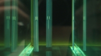 Three blades of the cycloidal turbine visible at the far end of a water tunnel in which th...